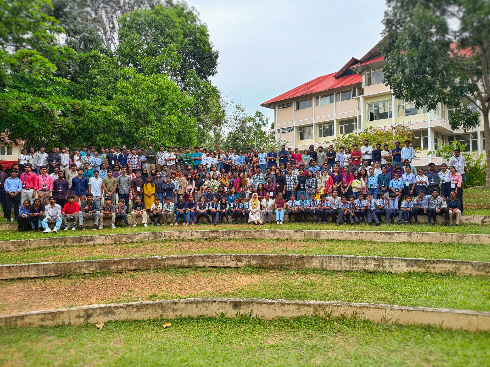 Wide view of the full participant crowd seated in a green amphitheater