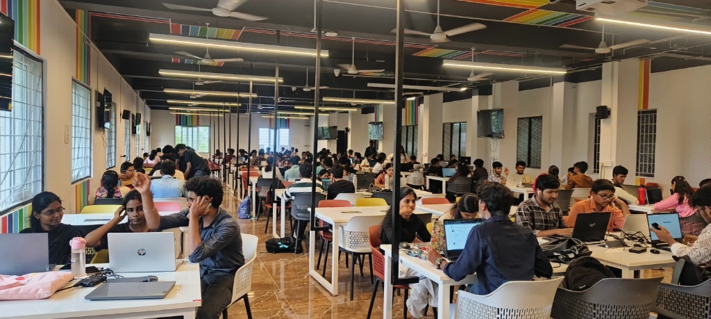 Space Apps participants collaborating at workstations across the hackathon hall